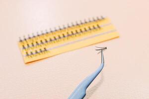 Artificial false fluffy eyelashes with tweezers. photo