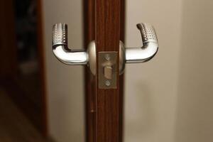 A door lock with a handle on the door in the apartment photo