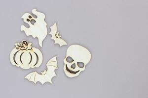 Wooden toy ghost, skull, bat on gray background Halloween concept photo
