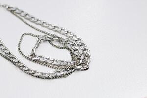 Different silver metal chains on a light background. photo