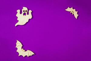 Wooden toy bat, ghost on purple background Halloween concept photo