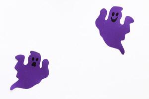papel fantasmas en un púrpura fondo, Víspera de Todos los Santos concepto foto