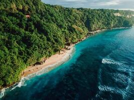 Holiday beach with turquoise tropical ocean in Bali. Drone view of Green bowl beach photo