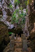 The beautiful views of the stalactite and stalagmite-filled cave in Lam Khlong Ngu National Park, Thailand. At the cave's exit is a small waterfall also. photo