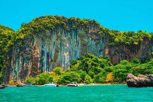 Aerial panorama of Thailand's verdant, lush tropical island, National Park Island, with blue and aquamarine the sea, and clouds shining by sunlight in the background. photo