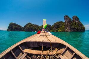 Aerial panorama of Thailand's verdant, lush tropical island, National Park Island, with blue and aquamarine the sea, and clouds shining by sunlight in the background. photo