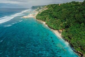 Aerial view of scenic coastline with turquoise ocean and beaches under cliffs in Bali. photo