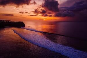 Aerial view of ocean with waves and colorful sunset or sunrise. photo