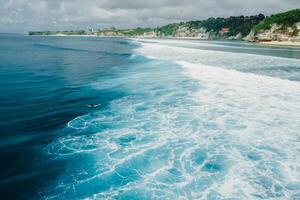 Aerial view of ocean with waves and coastline on Impossibles beach in Bali photo