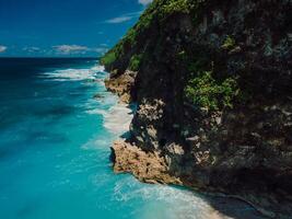 Scenic coastline with rocks and blue ocean with waves in Bali. Aerial view. photo