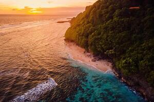 Ocean beach with sunset or sunrise tones in Bali. Aerial view photo