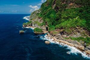 Scenic coastline with rocks and transparent ocean in Bali. Aerial view. photo