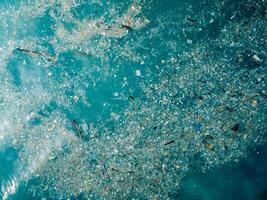 Ocean and plastic trash in Bali island. Aerial view of pollution by plastic rubbish in marina photo