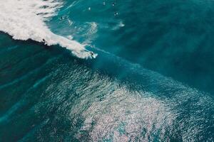 Aerial view with surfing on wave. Perfect waves with surfers in blue ocean photo