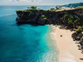 Aerial view of beach with rock and turquoise ocean in Bali photo