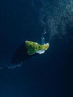 Scenic rock island in ocean nearby Nusa Penida. Aerial view photo