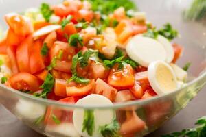 fresh vegetable salad, cabbage, tomatoes in a bowl on a wooden table photo