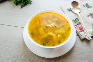 Homemade chicken vegetable soup on rustic wooden background photo