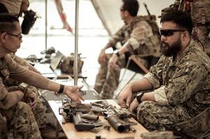 Soldiers in camouflage uniforms planning on operation in the camp, soldiers training in a military operation photo