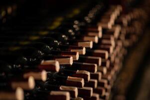 fila de vino botellas en un de madera estante en un vino cava foto