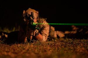 soldados en camuflaje uniformes puntería con su rifles listos a fuego durante militar operación a noche soldados formación en un militar operación foto