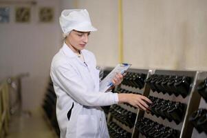 Professional winemaker controlling wine making process and quality at winery factory photo