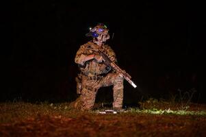 soldados Listo a fuego durante militar operación a noche foto
