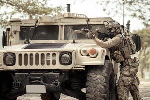 unido estados Ejército en camuflaje uniformes operación en el bosque con blindado vehículo, soldados formación en un militar operación foto