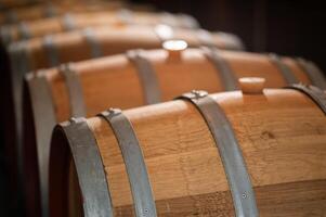 Old wooden wine barrels stacked in a cellar in order photo