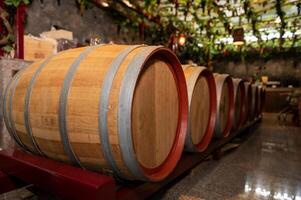 Old wooden wine barrels stacked in a cellar in order photo