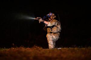 soldados en camuflaje uniformes puntería con su rifles listos a fuego durante militar operación a noche soldados formación en un militar operación foto