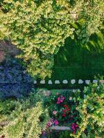 Landscape design with flower beds and path, natural landscaping panorama in home garden. Aerial view photo