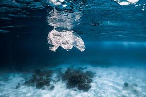Underwater view in ocean with plastic bag and rubbish, ecological problem photo