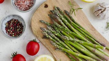 Fresh green asparagus lies on a wooden cutting board video