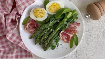 Frais asperges et prosciutto salade servi avec bouilli des œufs et microgreens video