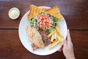 pork steak and chicken steak with French fries ,bread and salad or grilled pork and grilled chicken photo