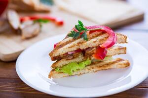 fried toast with chicken, salad, greens on a wooden table photo