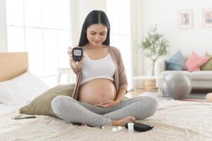 embarazada mujer comprobación sangre azúcar nivel por utilizando digital glucosa metro, salud cuidado, medicamento, diabetes, glicemia concepto foto