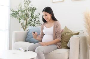 embarazada mujer comprobación sangre azúcar nivel por utilizando digital glucosa metro, salud cuidado, medicamento, diabetes, glicemia concepto foto