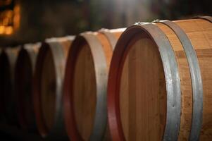 Old wooden wine barrels stacked in a cellar in order photo