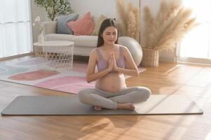 Healthy pregnant woman exercising and doing prenatal yoga, meditation, working out, yoga, pregnancy concept. photo