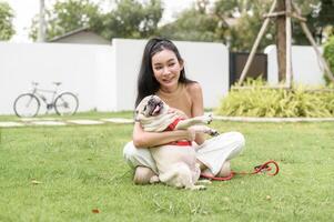 Happy asian woman playing with Cute Smart pug Puppy Dog In the Backyard photo