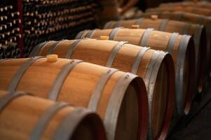 Old wooden wine barrels stacked in a cellar in order photo