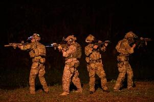 soldados Listo a fuego durante militar operación a noche foto