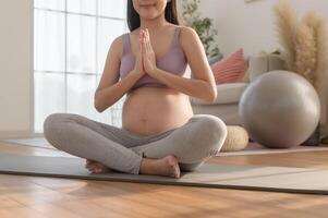 Healthy pregnant woman exercising and doing prenatal yoga, meditation, working out, yoga, pregnancy concept. photo