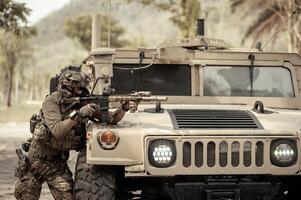 unido estados Ejército en camuflaje uniformes operación en el bosque con blindado vehículo, soldados formación en un militar operación foto