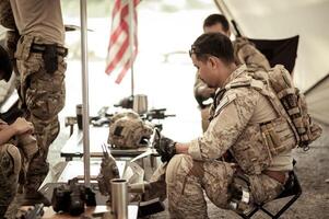 Soldiers in camouflage uniforms planning on operation in the camp photo