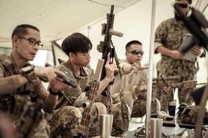 Soldiers in camouflage uniforms planning on operation in the camp, soldiers training in a military operation photo