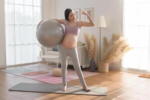 Healthy pregnant woman exercising and doing prenatal yoga, meditation, working out, yoga, pregnancy concept. photo