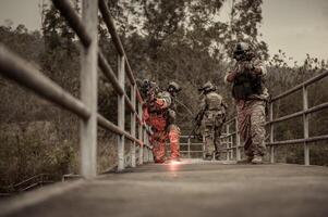 soldados en camuflaje uniformes puntería con su rifles Listo a fuego durante militar operación en el bosque , soldados formación en un militar operación foto